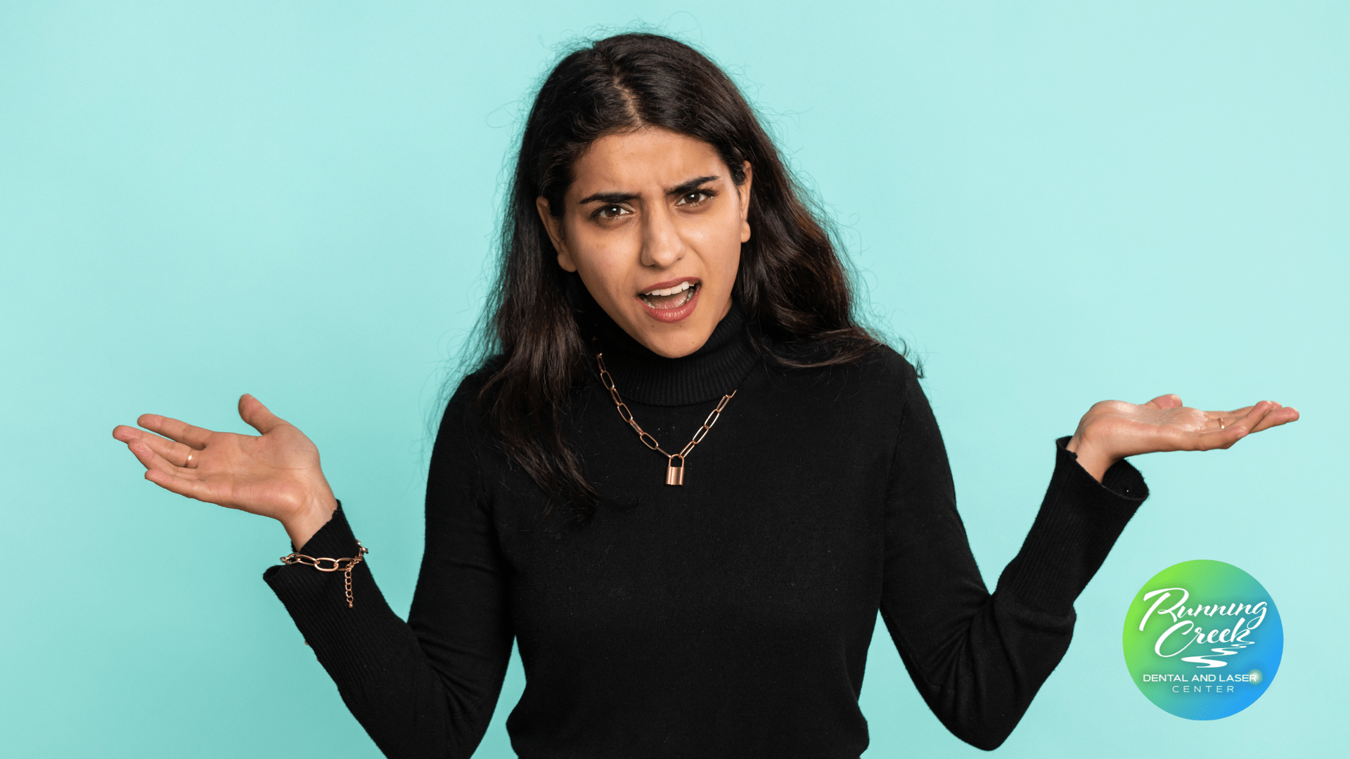 A woman in a black turtleneck is shrugging her shoulders.