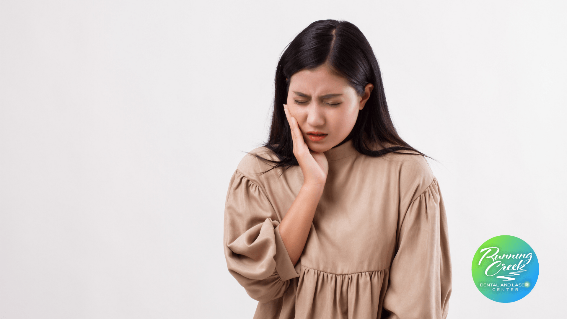 A woman is holding her face in pain because of a toothache.