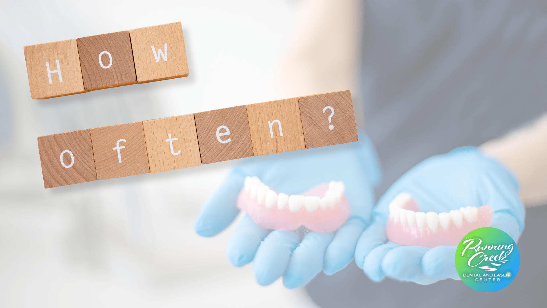 A person is holding a pair of dentures in their hands.