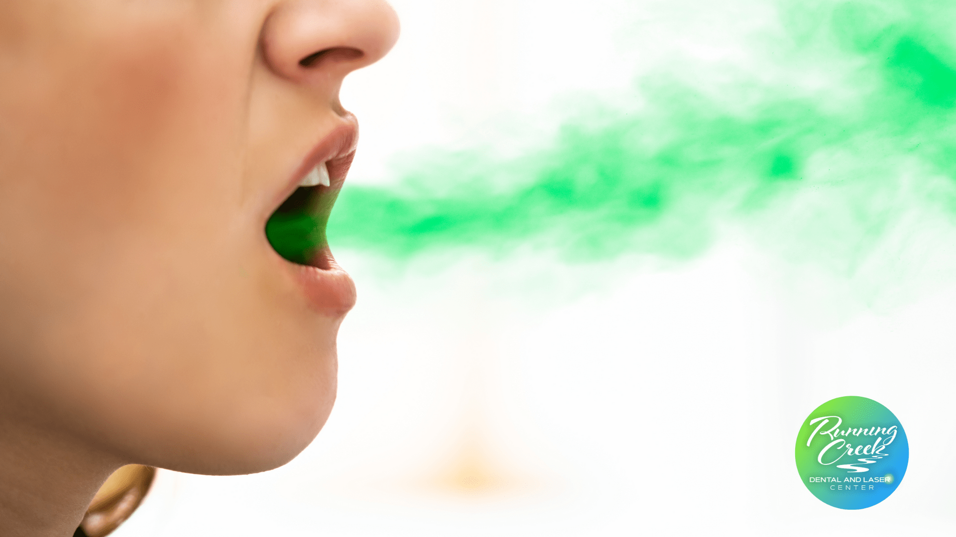 A close up of a woman 's mouth with green smoke coming out of it.