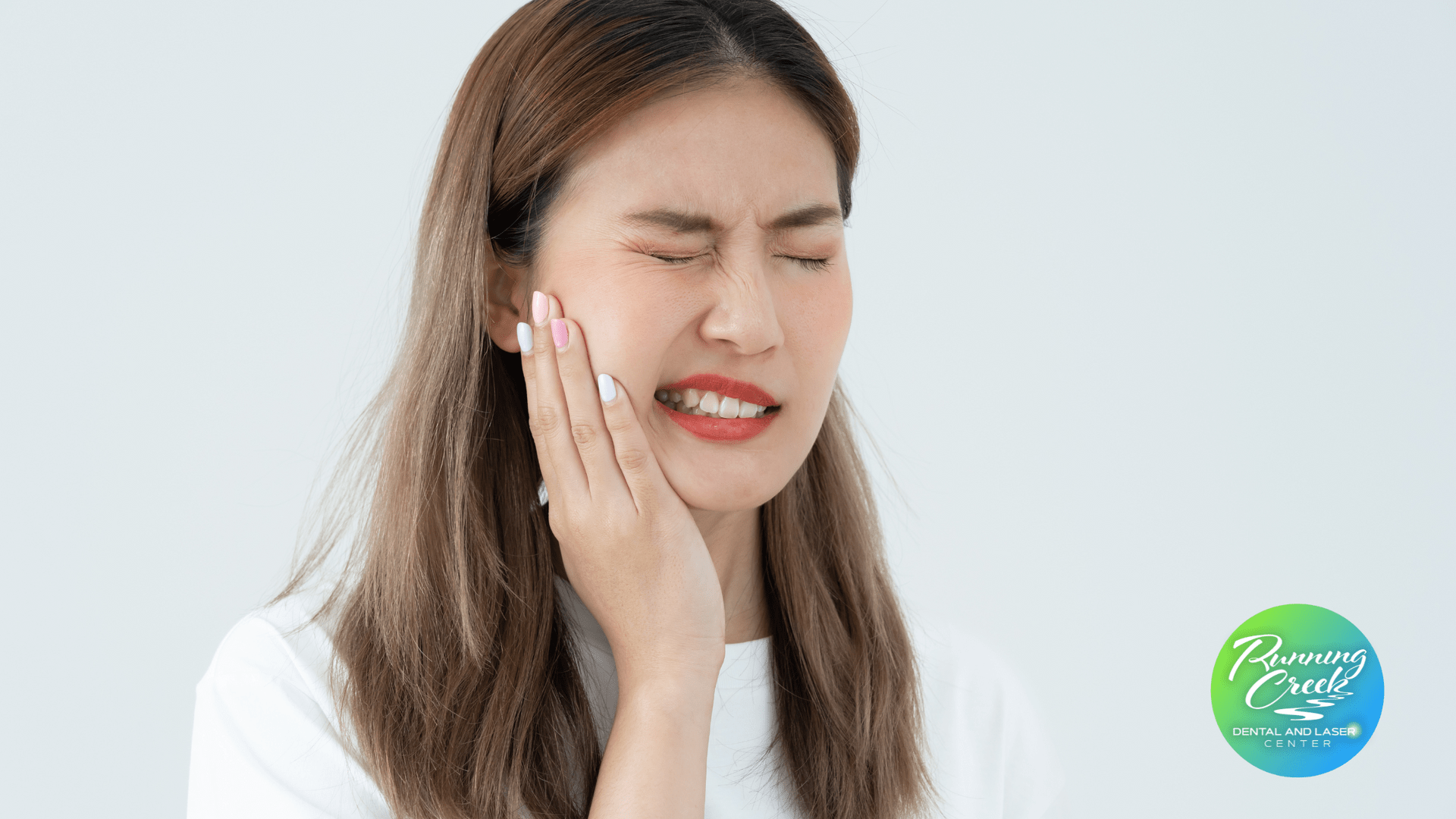A woman is holding her face in pain because of a toothache.