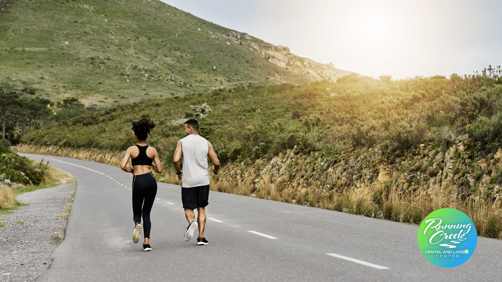 A man and a woman are running down a road.