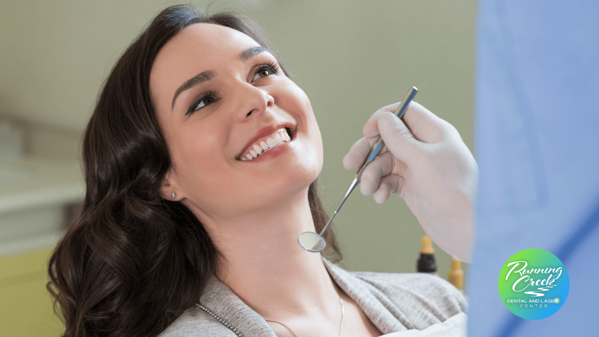 A woman is getting her teeth examined by a dentist.